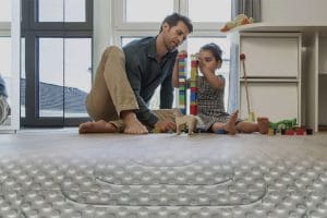 "Sıcak yerden ısıtma sistemi üzerinde oyun oynayan bir baba ve çocuğu. Bu sistem, çocuklar için konforlu ve güvenli bir zemin sunar."Altyazı ve Başlık Önerileri